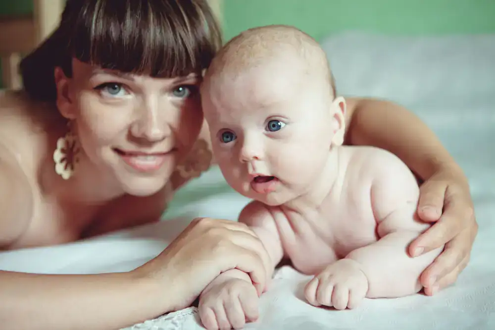 A mother and child laughing softly in a bright natural light studio setup