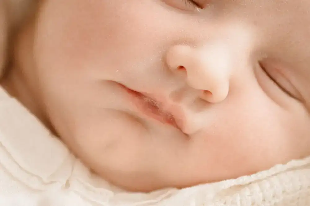 A close-up portrait of a newborn baby sleeping peacefully